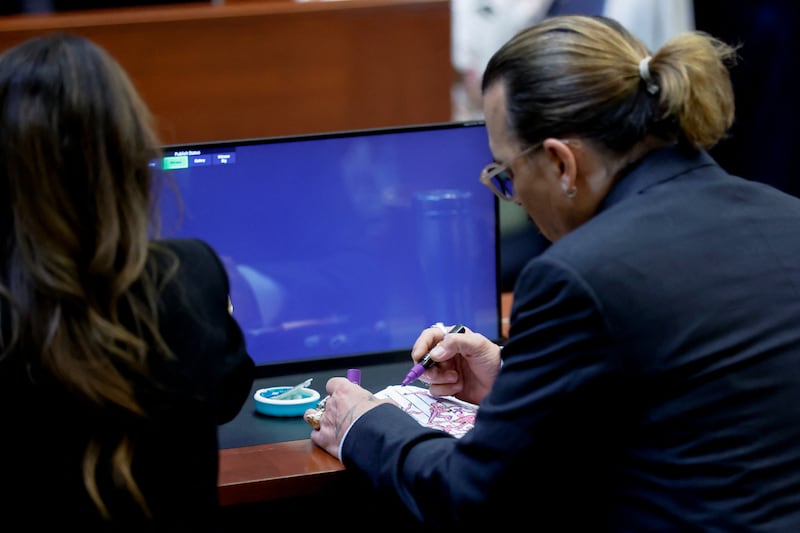 Depp draws in his sketchpad during the trial. Reuters