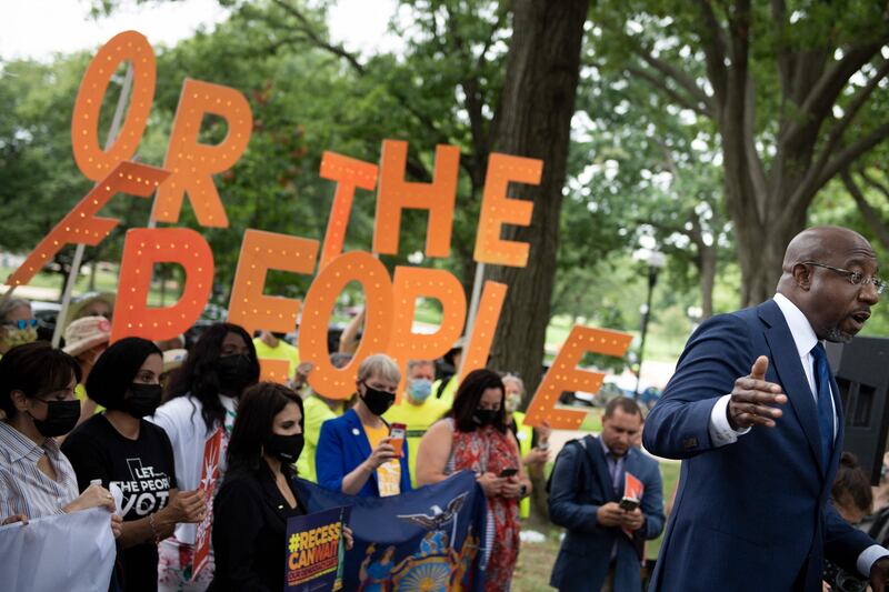 Mr Warnock speaks to people rallying for voters' rights on Capitol Hill in Washington. AFP