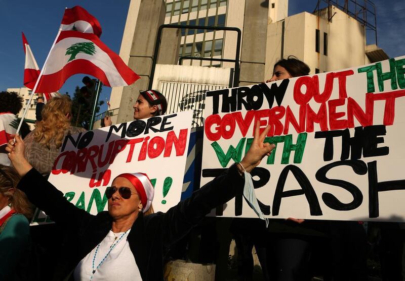 Lebanese women wave the national flag and hold placards as they take part in a protest in Beirut on March 12, 2016, against corruption and the garbage crisis. Patrick Baz / AFP