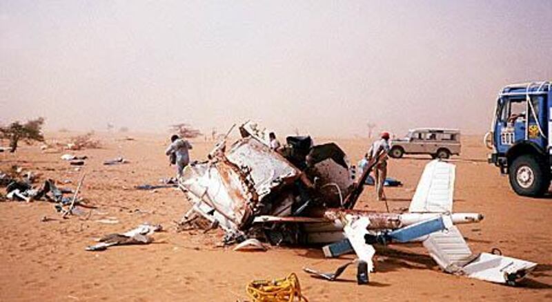 Competitors and officials search near the remains of the helicopter of the Paris-Dakar rally organizer Frenchman Thierry Sabine, after it crashed 14 January 1986 near Gourma-Rharous (Mali), while trying to rescue competitors lost in a heavy sand storm. All five persons onboard, with among them French singer Daniel Balavoine, died in the accident.