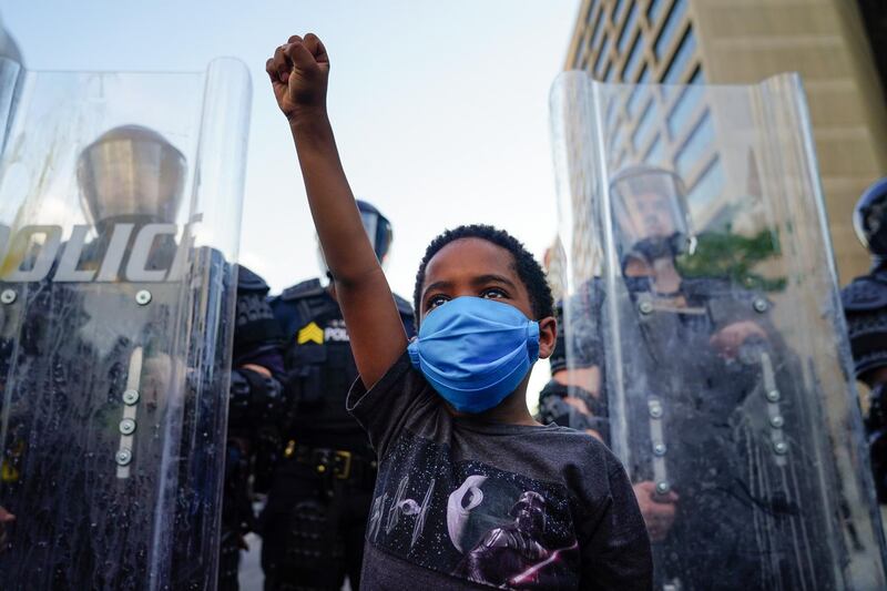 A young boy raises his fist for a photo by a family friend during a demonstration in Atlanta, Georgia. Getty Images
