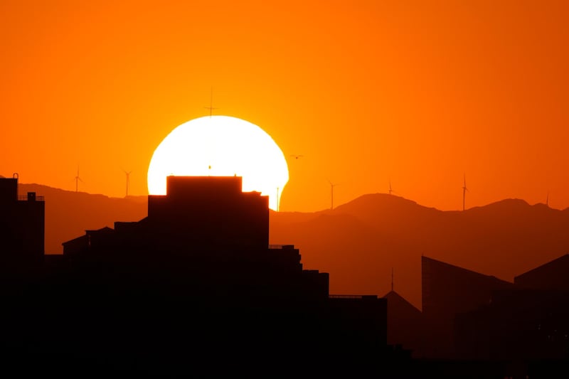 The sun is partially eclipsed as it sets over the horizon in Beijing. AP Photo