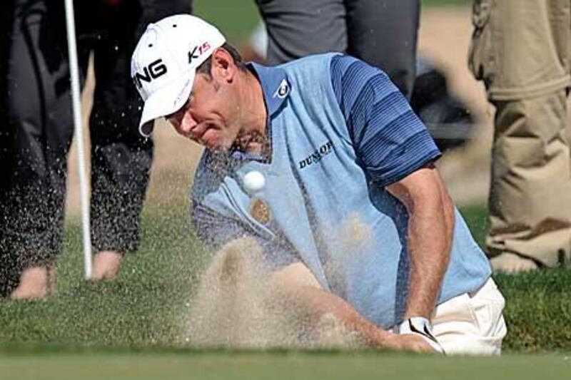 Lee Westwood of Britain hits out of a bunker on the fifth green during the second round in Doha.