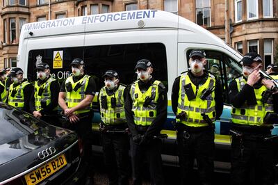 Protestors surround an Immigration Enforcement van to stop it from departing after individuals were detained in Glasgow on May 13, 2021. / AFP / Andy Buchanan
