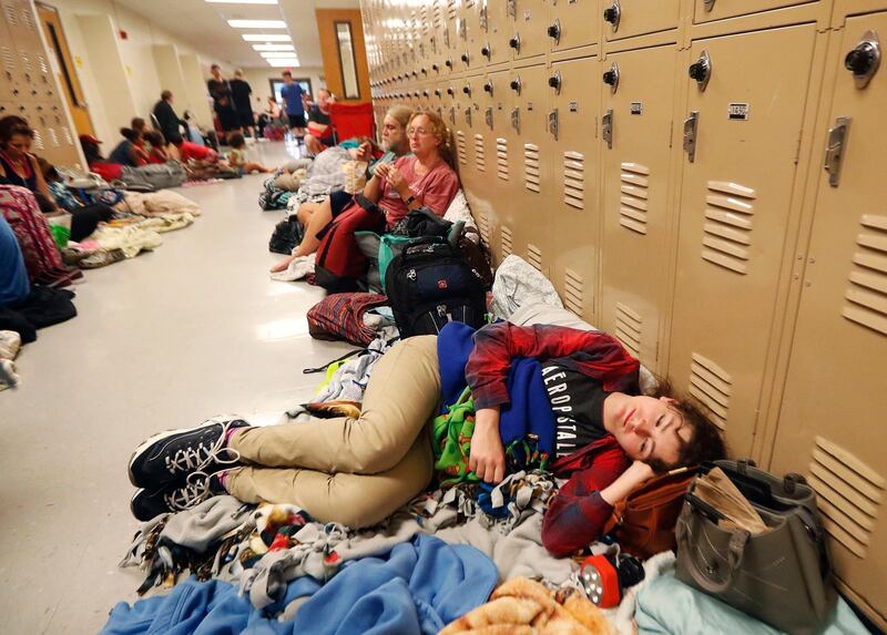 Emily Hindle lies on the floor at an evacuation shelter set up at Rutherford High School in Panama City Beach. AP