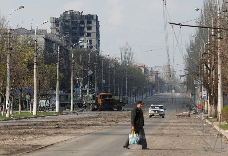 A local resident crosses a street damaged during the Ukraine-Russia conflict in the southern port city of Mariupol, Ukraine. Reuters