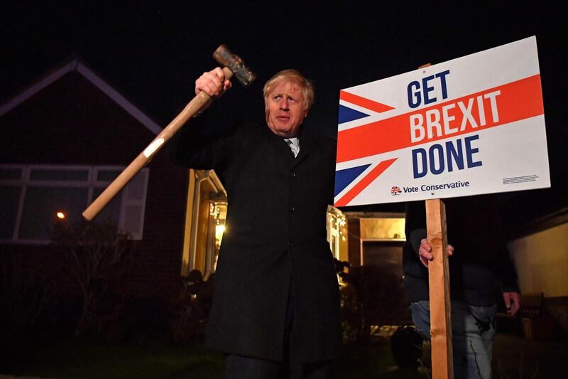 (FILES) In this file photo taken on December 11, 2019, Britain's Prime Minister and Conservative party leader Boris Johnson poses after hammering a "Get Brexit Done" sign into the garden of a supporter, with a sledgehammer as he campaigns with his team in Benfleet, east of London. From the Arab Spring to bloodletting in Syria, from Obama to Trump, from terror in the streets of Paris to Brexit, the 2010s began with hope for a more equitable world, and end with a slide towards nationalistic populism. / AFP / POOL / Ben STANSALL / TO GO WITH AFP STORY by AFP bureaux, with Herve Rouach, "Trump, Syria and Facebook: the volatile cocktail of the 2010s"
