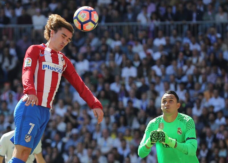 Atletico Madrid's Antoine Griezmann heads a ball while Real Madrid goalkeeper Keylor Navas looks to save. Sergio Perez / Reuters
