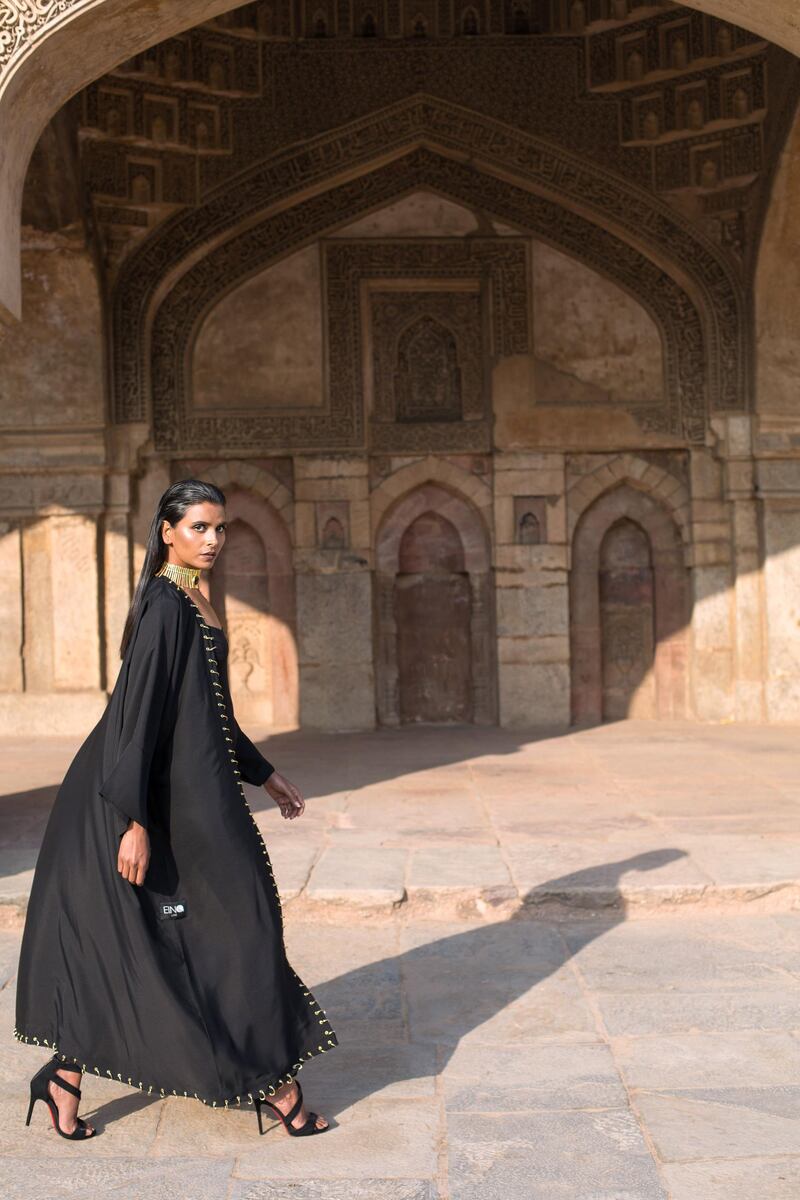 Open-cut black abaya with gold eyelets and hoops from The Edit