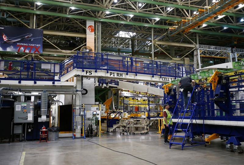 Employees work on part of the 777X wing assembly.