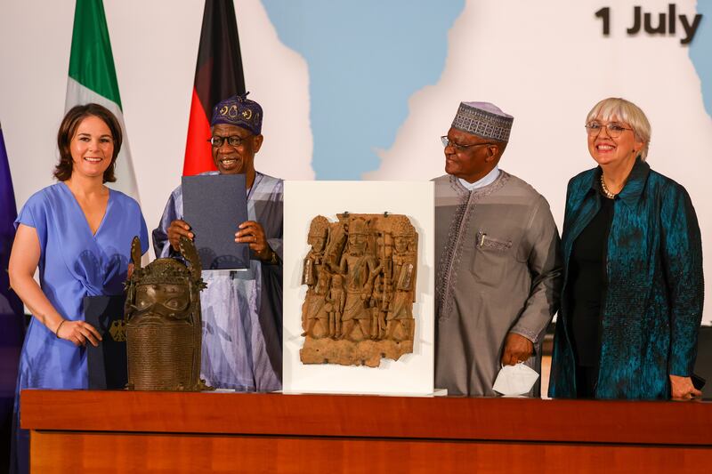 Nigeria's Culture Minister holds a signed declaration after Germany's Foreign Minister Annalena Baerbock, left, returned the first batch of Benin Bronzes last year. Getty Images
