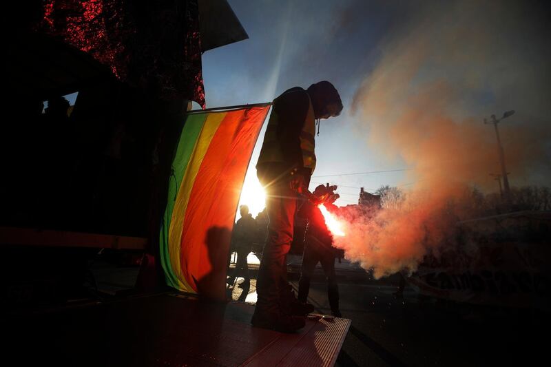 A demonstrator holds a flare during a student protest against the Italian government, in Milan, Italy. AP Photo