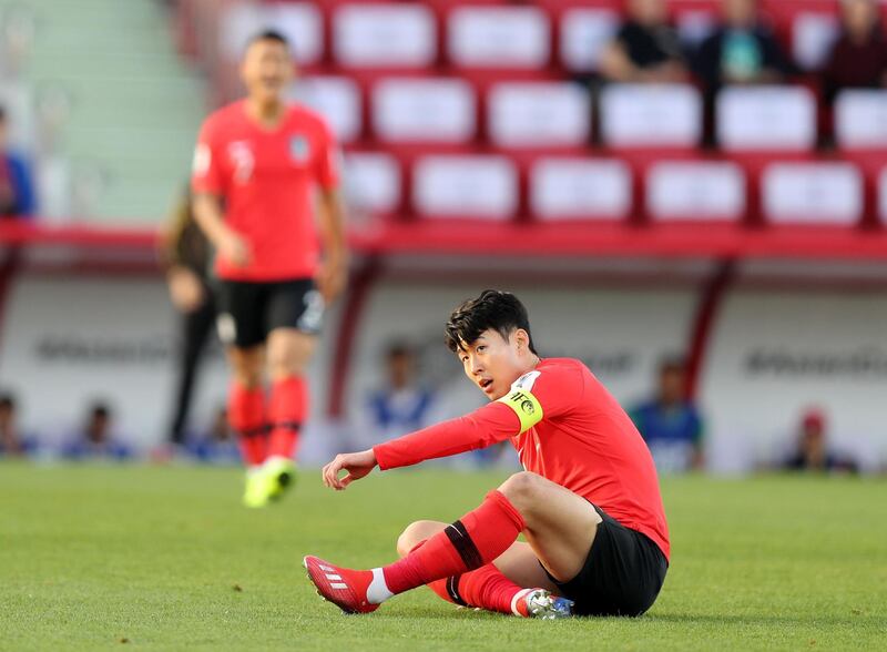 Dubai, United Arab Emirates - January 22, 2019: Son Heung-min of South Korea lies down after a tackle in the game between South Korea and Bahrain in the Asian Cup 2019. Tuesday, January 22nd, 2019 at Rashid Stadium, Dubai. Chris Whiteoak/The National