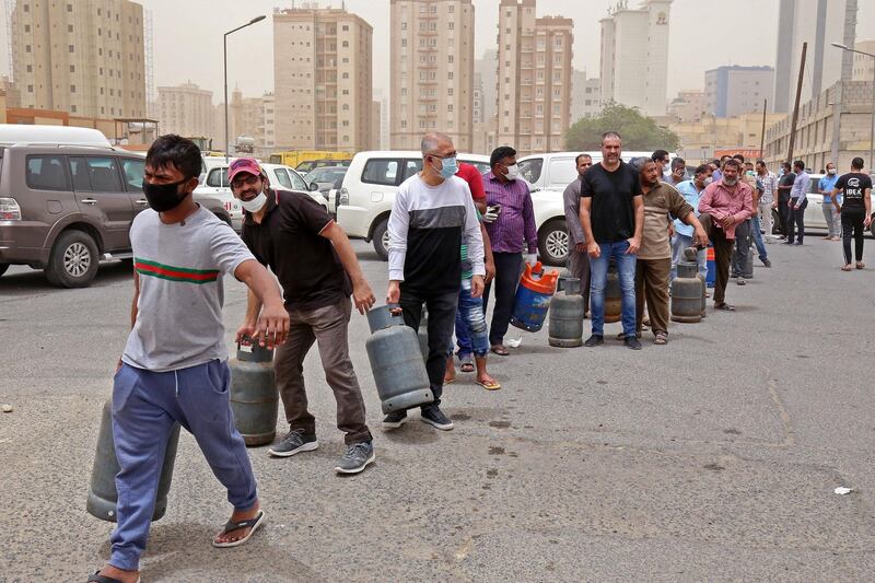 People queue in front of a shop to refill their gas cylinders in Kuwait City, a day after Kuwaiti authorities announced a 20-day total lockdown to tackle the Covid-19 pandemic. AFP