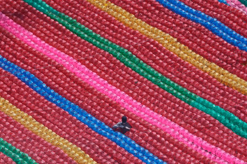 A worker checks the electric wires to hang lanterns for Buddha's birthday celebrations on May 8 at Jogye temple in Seoul, South Korea. AP