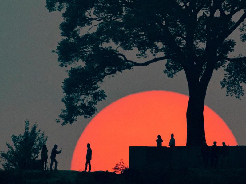 People gather to watch the last sunset of the year 2077 of the Nepali calendar at Single Tree Hill, Kathmandu. The Nepali New Year 2078 began on April 14. EPA