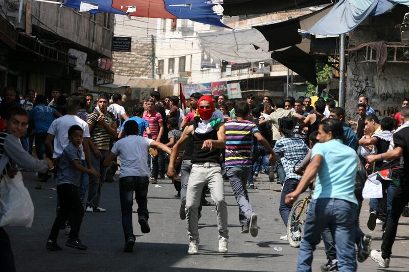 epa02927721 Palestinian youths throw stones towards Israeli soldiers (not pictured) during a protest in the West Bank city of Hebron 21 September 2011, as Palestinian president Mahmud Abbas prepares to submit a formal request for Palestine to become the 194th member of the United Nations despite US and Israeli opposition.  EPA/ABED AL HASHLAMOUN *** Local Caption ***  02927721.jpg