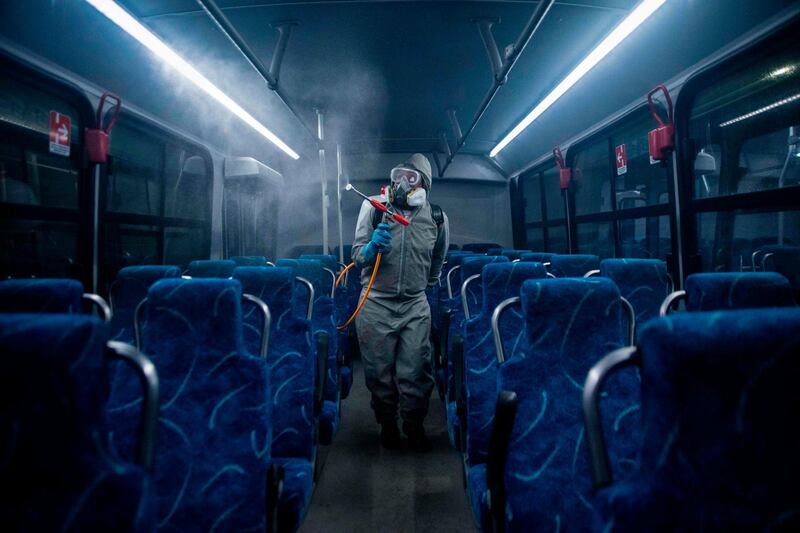 A cleaner wearing personal protective equipment disinfects a bus at a terminal in Coatepec, Veracruz state, on the coast of the Gulf of Mexico. AFP