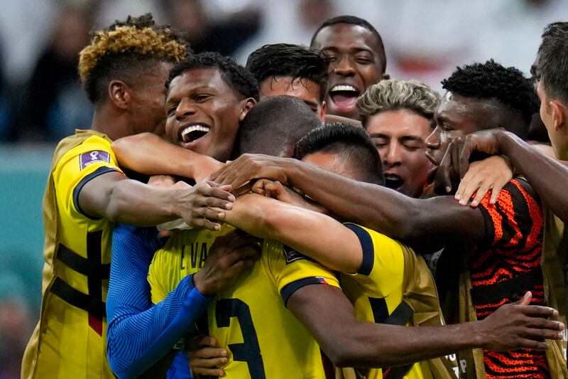 Teammates embrace Ecuador's Enner Valencia after he scored his side's second goal against Qatar. AP Photo