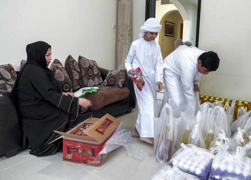 Abu Dhabi, United Arab Emirates, April 30, 2020.   
 Filipino woman, Mona Mohamed Baraguir who donates rice, eggs, cooking oil and other daily essentials to laid off workers.
Mona with her children, (L-R) Fares-9, Hamed Khalifa-15,  Ali-13 and Saed- 11. 
The boys help pack the daily supplies.
Victor Besa / The National
Section:  NA
Reporter:  Shireena Al Nuwais