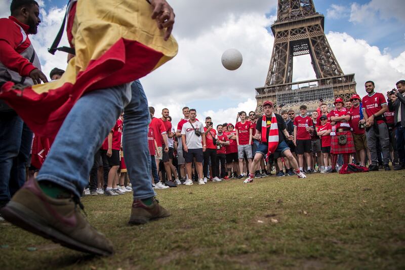 Liverpool and Real Madrid's fans play football near the Eiffel Tower. EPA