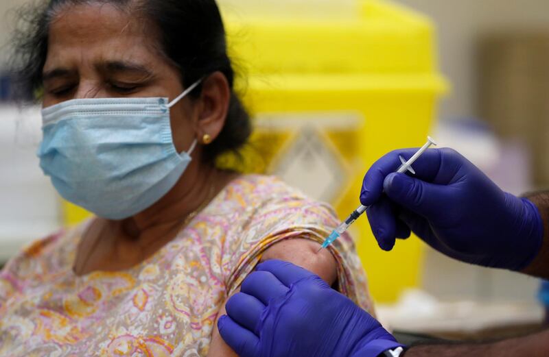 A patient is injected with the Pfizer/BioNtech vaccine at the Fullwell Cross Medical Centre. Dr. Anil Mehta, a local doctor, said health officials are making every effort to reach the poorest and hardest to reach communities. AP Photo