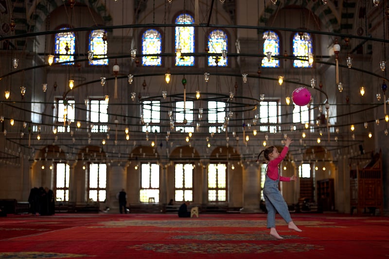 A girl plays with a balloon inside Fatih Mosque in Istanbul, Turkey. AP Photo