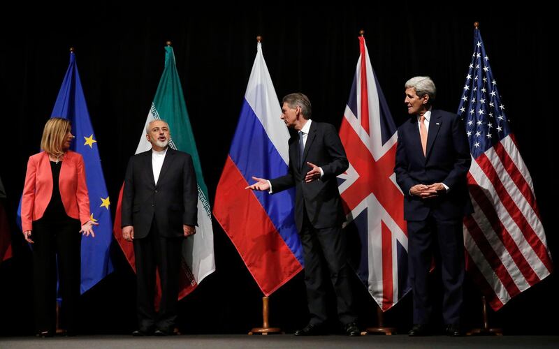 FILE - In this July 14, 2015 file photo, British Foreign Secretary Philip Hammond, 2nd right, U.S. Secretary of State John Kerry, right, and European Union High Representative for Foreign Affairs and Security Policy Federica Mogherini, left, talk to Iranian Foreign Minister Mohammad Javad Zarif as the wait for Russian Foreign Minister Sergey Lavrov, for a group picture in Vienna, Austria. President Hassan Rouhani is reportedly set to announce Wednesday, May 8, 2019, ways the Islamic Republic will react to continued U.S. pressure after President Donald Trump pulled America from Tehranâ€™s nuclear deal with world powers. (Carlos Barria, Pool Photo via AP, File)