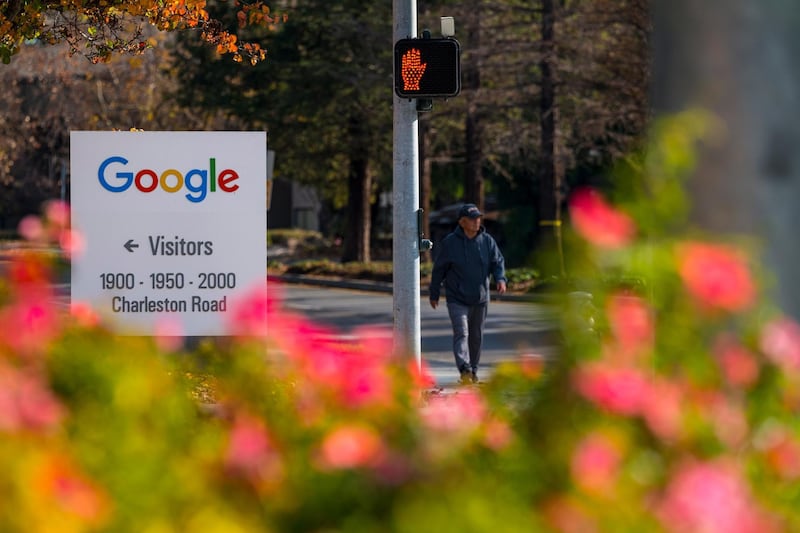 A pedestrian walks past directional signage at the Google campus in Mountain View, California, U.S., on Wednesday, Dec. 16, 2020. On Wednesday, Texas Attorney General Ken Paxton filed an antitrust lawsuit against Alphabet Inc.'s Google. At its center is a bold claim: Google colluded with archrival Facebook Inc. in an illegal deal to manipulate auctions for online advertising, an industry the two companies dominate. Photographer: David Paul Morris/Bloomberg