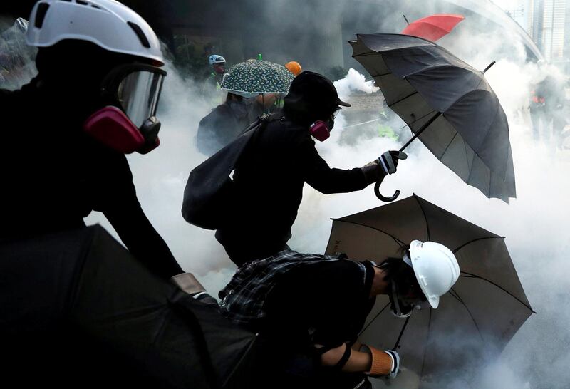 Anti-government protesters protect themselves with umbrellas among tear gas during a demonstration near Central Government Complex in Hong Kong, China, September 15, 2019. REUTERS/Jorge Silva