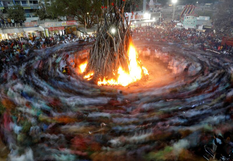 Hindu devotees walk around a bonfire during a ritual known as 'Holika Dahan' on the outskirts of Ahmedabad, in Gujarat. Reuters