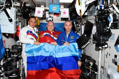 Cosmonauts Oleg Artemyev (C), Denis Matveyev (R) and Sergei Korsakov pose with a flag of the self-proclaimed Luhansk People's Republic on board the International Space Station. The anti-Ukraine gesture was widely condemned. AFP