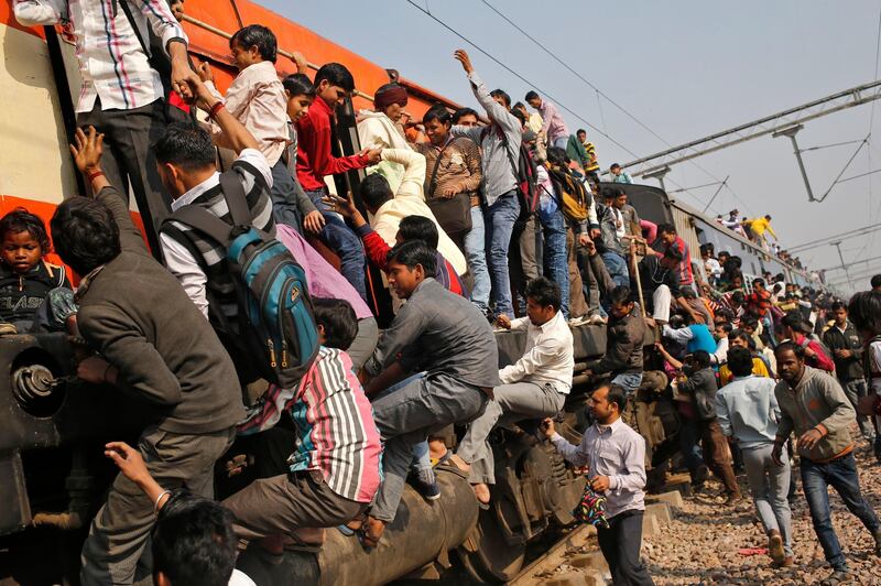 Passengers board an overcrowded train near a railway station at Loni town in the northern state of Uttar Pradesh, India, February 24, 2016. India's federal-run railways will have to depend on more government support and borrowing to fix their finances in its budget on Thursday, with New Delhi reluctant to unveil steep fare hikes ahead of key state elections, officials said. REUTERS/Anindito Mukherjee - D1AESOWIOAAA