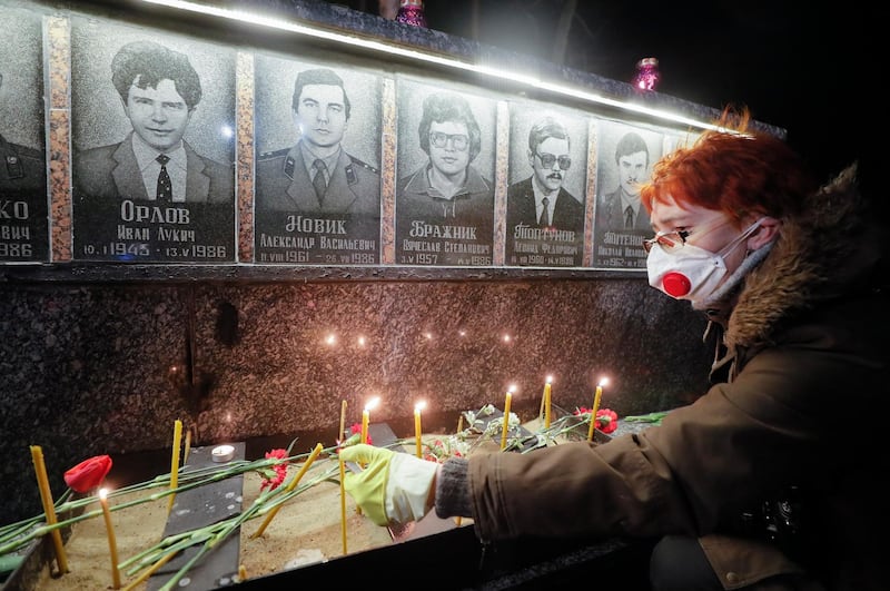 Ukrainians light candles and lay flowers at the memorial for 'liquidators' who died during cleaning up works after the Chernobyl nuclear power plant disaster, during a ceremony in Slavutich city.  EPA