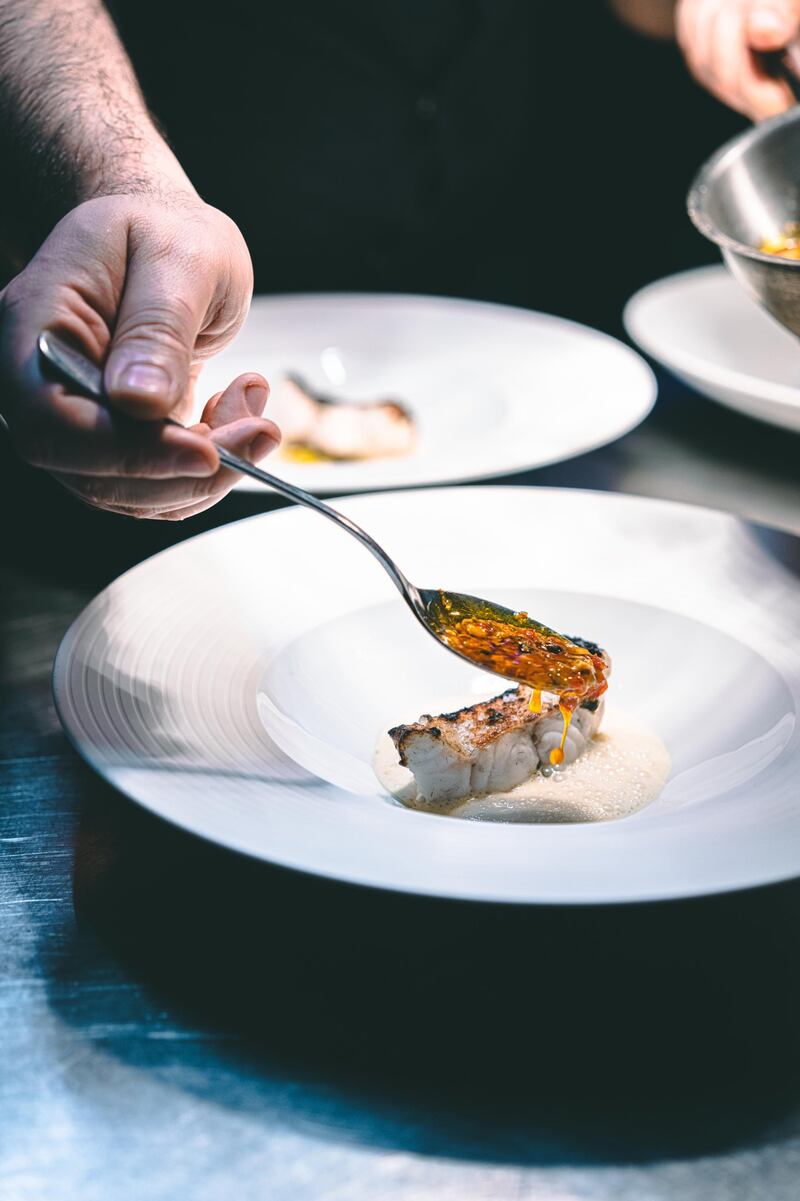 Michelin starred chef Gal Ben-Moshe will serve grilled white grouper, marinated in shio koji, charred leeks, brown butter, unripe grapes, Verjus beurre blanc and mussels XO sauce at a nine-course dinner at Jubilee restaurant at Expo 2020 Dubai for VIP guests. Photo: @PrismChefBerlin Twitter