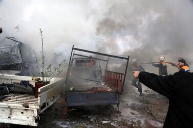 Firefighters try to extinguish flames at the site of the air strike targeting the industrial area in the east of Idlib. EPA