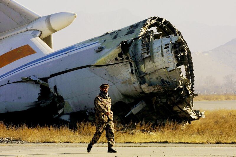 399310 16: An Afghan Northern Alliance soldier walks by the wreckage of an aircraft at Kabul International Airport January 7, 2002 as the airport prepares to reopen to international flights shortly. (Photo by Paula Bronstein/Getty Images)