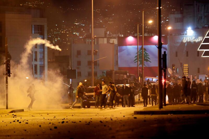 Lebanese demonstrators hurl tear-gas canisters back at riot police during clashes in the capital Beirut on December 14, 2019. AFP