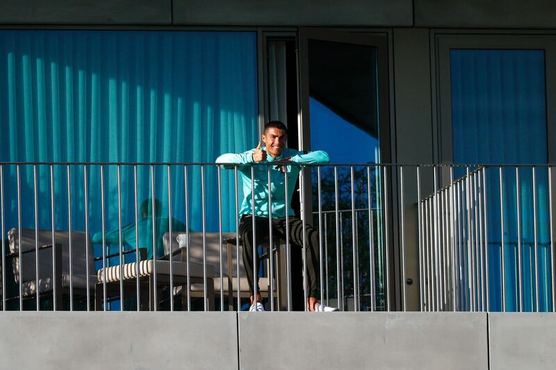 Cristiano Ronaldo watches his teammates train from a balcony. EPA