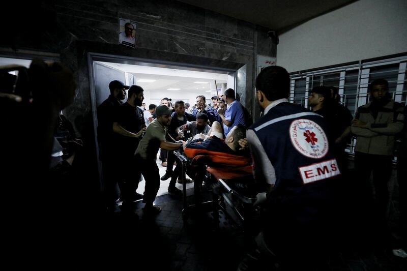 An injured person is assisted after a missile strike on Al Ahli Arab Hospital on October 17. Reuters