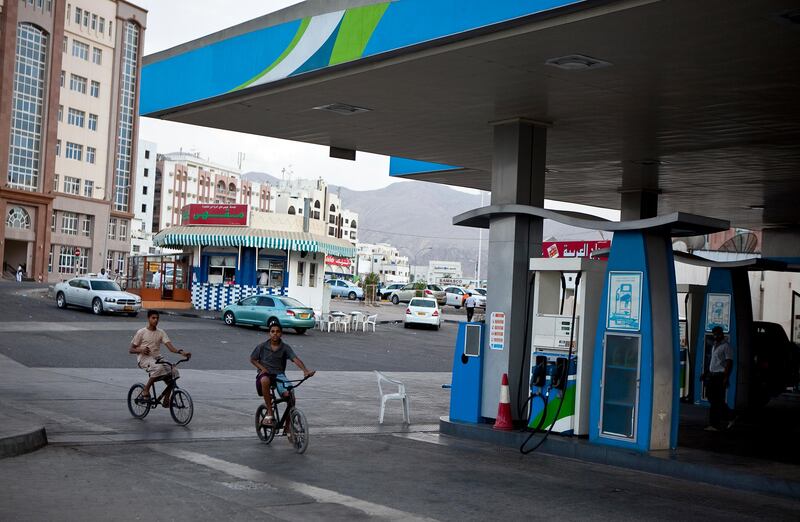 A couple of boys bike pass an Oman Oil gas station in Muscat, the capital of the Sultanate of Oman on Wednesday, Oct. 12, 2011. (Silvia Razgova/The National)

