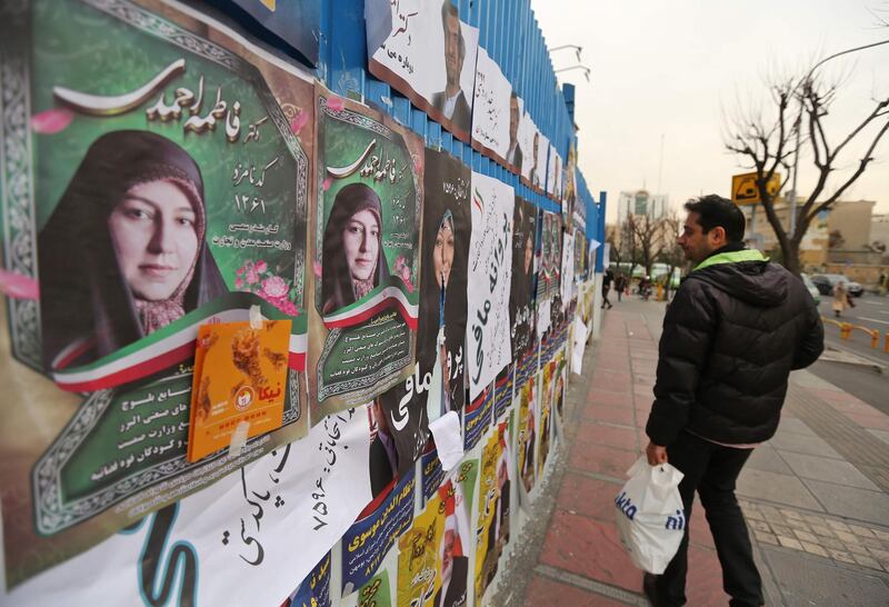 An Iranian man walks past electoral posters in Tehran. AFP