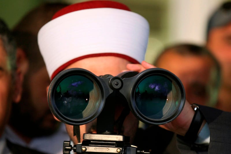 A Jordanian Muslim cleric looks through a telescope to observe the moon in order to determine the start date for the Muslim holy month of Ramadan in Amman, Jordan, Saturday July 30, 2011.  Clerics announced that Monday Aug. 1 will be the first day of Ramadan. (AP Photo/Nader Daoud) *** Local Caption ***  Mideast Jordan Ramadan.JPEG-0d10e.jpg