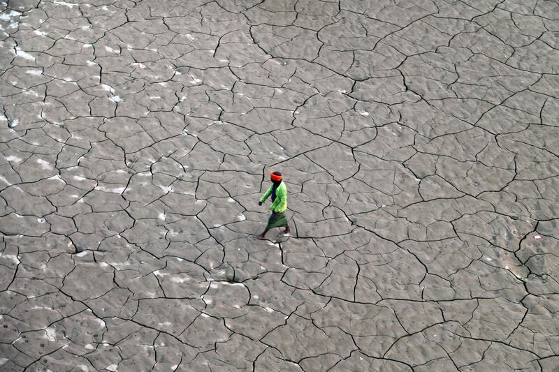 A man crossing the Ganges' dry river bed in Prayagraj, India. AFP