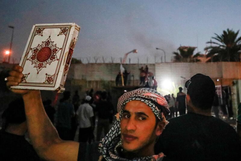 A supporter of Shiite cleric Moqtada al Sadr holds up a copy of the Quran at the protest in Baghdad. AFP