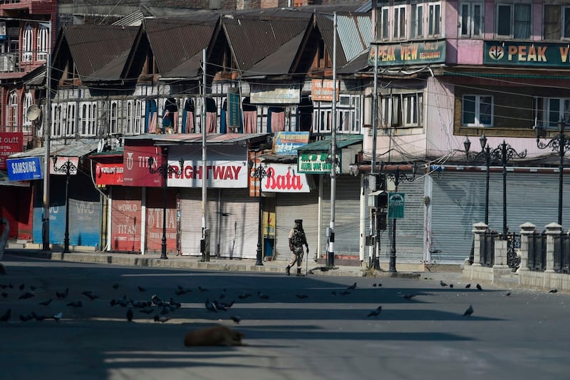 (FILES) In this file photo taken on September 8, 2019 an Indian paramilitary trooper patrols along an empty street during a strict curfew in Srinagar. The coffee machines have been cold, computer screens blank and work stations empty for two months in Kashmir's Silicon Valley as an Indian communications blockade on the troubled region takes a growing toll on business.
 / AFP / Tauseef MUSTAFA / To go with INDIA-KASHMIR-UNREST-POLITICS-ECONOMY,FOCUS
