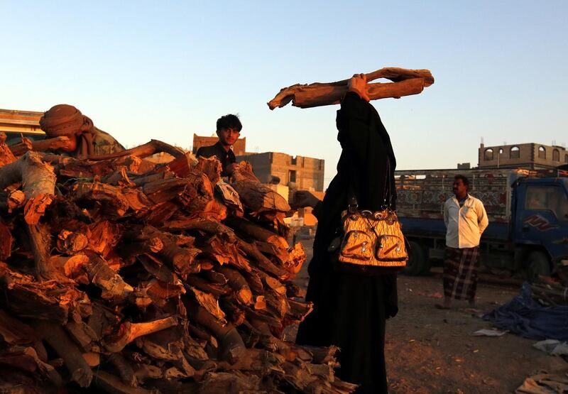 A Yemeni woman carries a bundle of firewood amid a severe cooking gas shortage, at a firewood market in Sana'a, Yemen. EPA