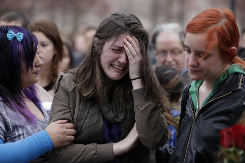 Emma MacDonald, 21, center, cries during a vigil for the victims of the Boston Marathon explosions at Boston Common, Tuesday, April 16, 2013. Twin explosions near the marathon’s finish line Monday killed three people, wounded more than 170 and reawakened fears of terrorism. (AP Photo/Julio Cortez) *** Local Caption ***  APTOPIX Boston Marathon Explosions.JPEG-069e1.jpg