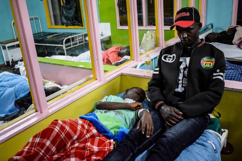A parent sits next to her daughter as she gets treatment at Kakamega Hospital in Western Kenya on January 4, 2020.  14 pupils lost their lives while 39 others were injured following a stampede at Kakamega Primary School on 3rd February 2020 as the pupils rushed to get home according to the Kenya Police. / AFP / BRIAN ONGORO
