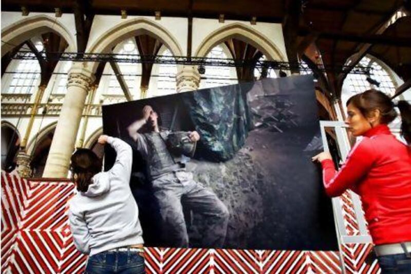 Tim Hetherington's winning entry in the World Press Photo 2008 competition is carried into an exhibition at the Oude Kerk church in Amsterdam. Robin Utrecht / EPA